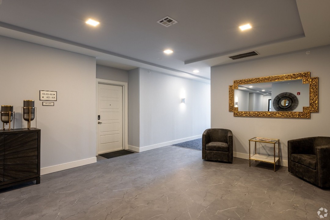 Building lobby entrance with red accent wall and polished concrete floors